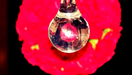 Brilliant crystal drop on red abstract backgroundの写真素材