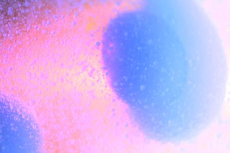 Art blue paint drops in pink water abstract background