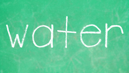 Water written woth chalk on green boardの写真素材