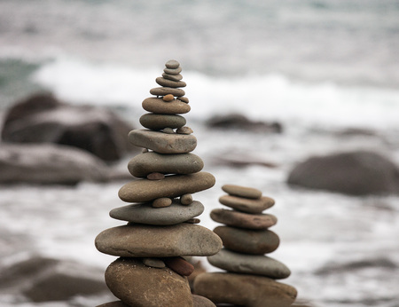 Pebbles on the sea coast. Little cairn on the background of the sea. Landscape for meditation.