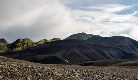Dramatic iceland landscape with a green hill and black lava looks like a moonの写真素材