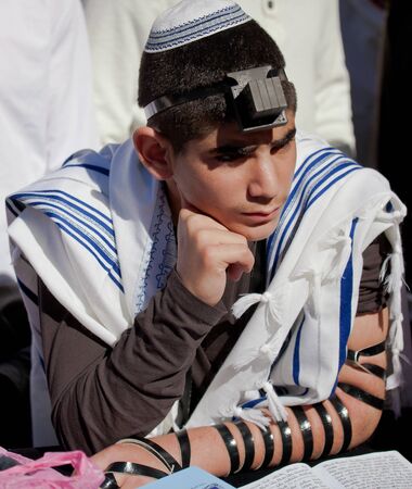 JERUSALEM, ISRAEL - Feb 18, 2013: Bar Mitzvah ritual at the Wailing wall in Jerusalem. A 13 years old boy who has become Bar Mitzvah is morally and ethically responsible for his decisions and actionsのeditorial素材