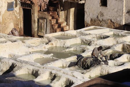 Fez, Morocco - January 01, 2010: Workers are dyeing and tanning leather at the tannery in Fez using the traditional method with pigeon dung and salt. Fes el Bali, Morocco, Africa.のeditorial素材