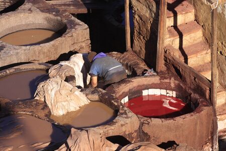 Fez, Morocco - January 01, 2010: Workers are dyeing and tanning leather at the tannery in Fez using the traditional method with pigeon dung and salt. Fes el Bali, Morocco, Africaのeditorial素材