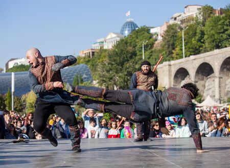 GEORGIA, TBILISI-07 OCTOBER 2017: Warriors dressed in Georgian national costumes hold knives, swords and shields and fight on Tbilisoba holiday. October festivalのeditorial素材
