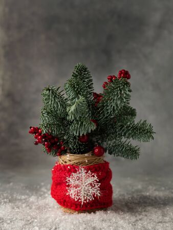 Zero waste style Christmas decoration with fir on grey background in a cup wrapped in knitten scarf.の写真素材