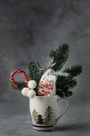 A Christmas sweet gift with fir, marshmellow, sweets in a cup.の写真素材