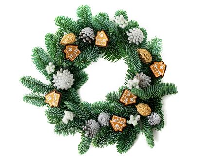 A traditional green christmas wreath isolated with houses and silver cones as a decoration.の写真素材