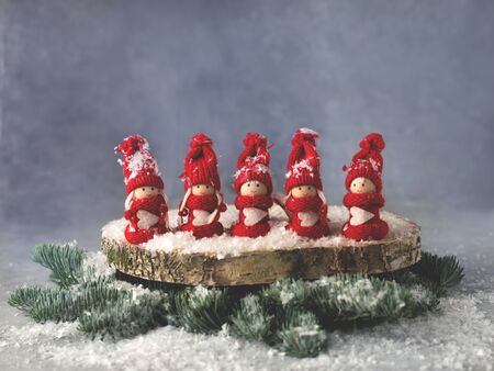A table Christmas decoration with five red figurines of girls in Christmas suits.の写真素材