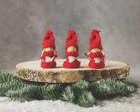 A table Christmas decoration with three red figurines of girls in Christmas suits.の写真素材