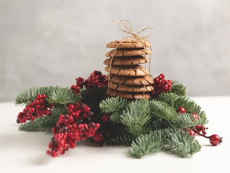 Homemade cookies tied with a rope on the top of a Christmas composition with branch of fir with copyspace.の写真素材