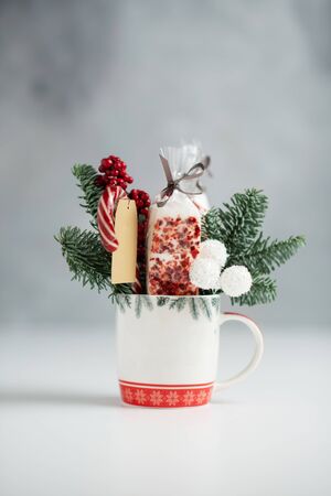 A Christmas sweet gift with fir, marshmellow, sweets in a mug with copy space on a blured background.の写真素材
