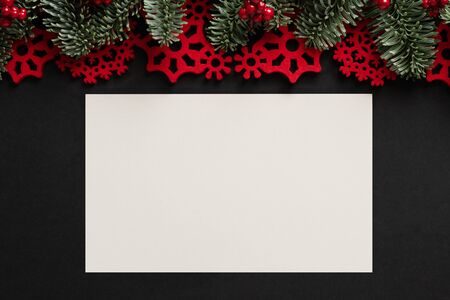 Christmas gift card with on black background with decorated with fir and red decoration.の写真素材