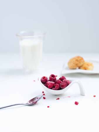 Delicious healthy breakfast with coconut cookies, rasberries and milk in glass as a background on a white background.の写真素材
