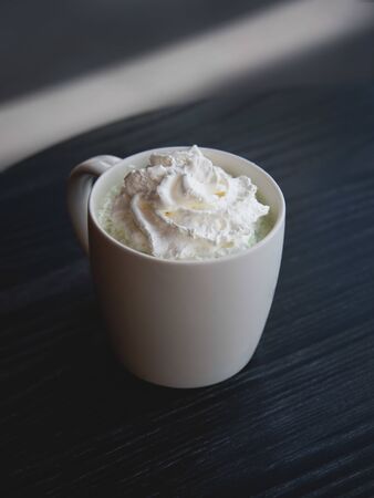 White mug of latte with selective focus - Freshly brewed matcha latte - top view.の写真素材