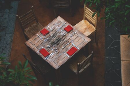 Top view of a rustic table served with red napkin, wineglass at an outdoor restaurant.の写真素材