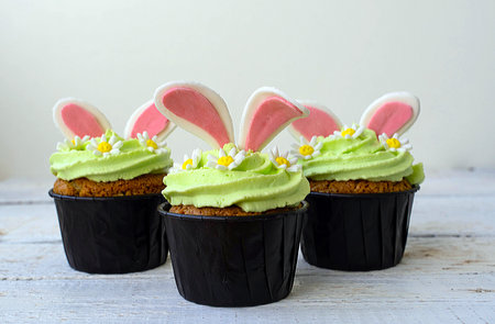 Easter cupcake with whipped green cream. Bunny ears stick out and daisies.の写真素材