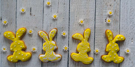 Frame from cookies for Easter. Bunny and eggs decorated with icing dry on white rustic wooden table....