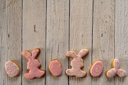 Making cookies for Easter. Bunny and eggs decorated with icing dry on the wire rack. Homemade Easter gingerbread. Bright colors.の写真素材