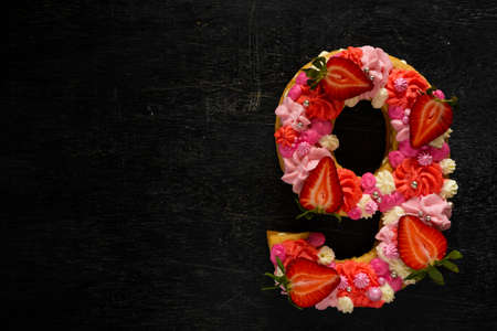 Beautiful cake in the shape of number 9. Modern trendy design. Springtime decoration. Copy space....