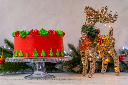Christmas cake decorated with Christmas trees. Deer with a flashing Christmas garland. Decoration for the holiday. Beautifully served table for the celebration. Copy space.の写真素材