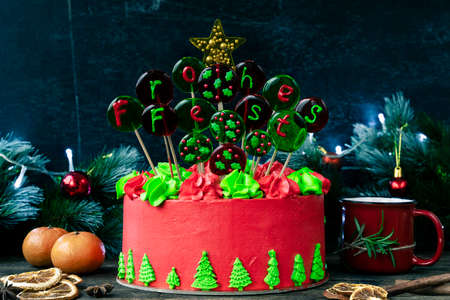 Christmas cake with balls with an inscription in German Frohes Fest Happy holidaya cup of tea with cinnamon and star anise. Decoration for the holiday. Beautifully served table for the celebration.の写真素材