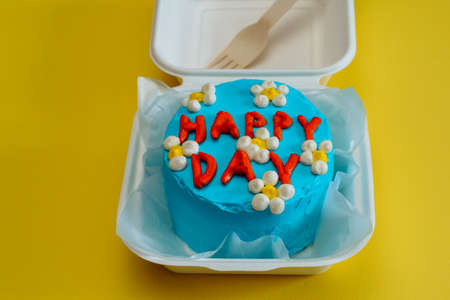 Asian bento cake box , blue cake with daisies, happy day inscription. Delicious beautiful dessert. Small gift holiday. Korean style cakes box wooden fork one person.の写真素材