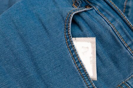 condom in front pocket of blue jeans pants top view