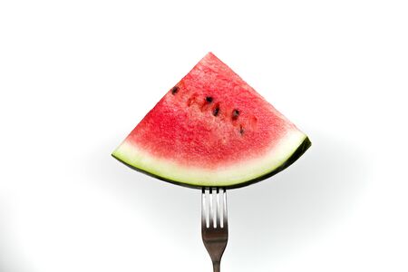 a piece of ripe juicy watermelon on a fork white background place copy isolationの写真素材