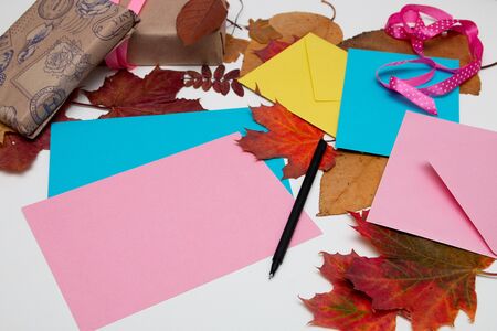 envelopes, cards, thanksgiving gifts, beautiful autumn maple leaves on a white table, copy space....
