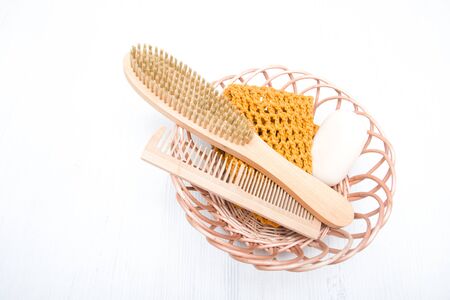 wooden comb, brush, soap, washcloth made of natural material in a basket on a gray background, eco friendly concept, spa, body careの写真素材