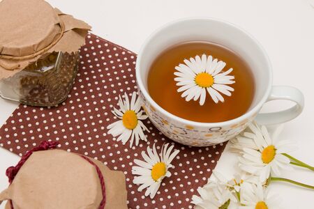 still life of tea cans and cups of tea with brown polka dots on a white table isolation top view place copyの写真素材