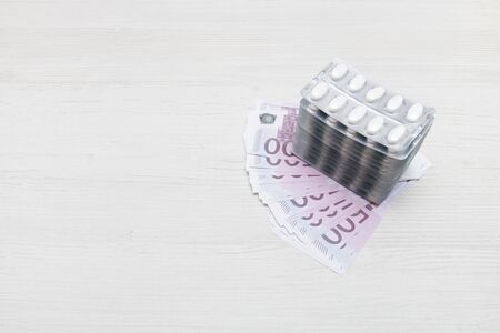 a stack of packs of pills on 500-euro bills, business in medicine concept, copy space, top view,...