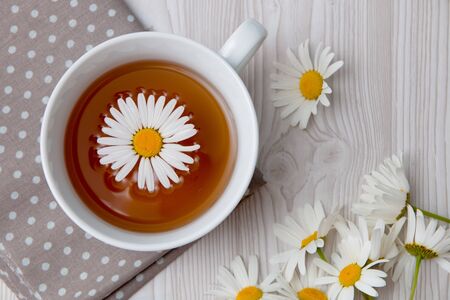 cup of tea camomile in it on a brown polka dot fabric on a white background  top view copy spaceの写真素材