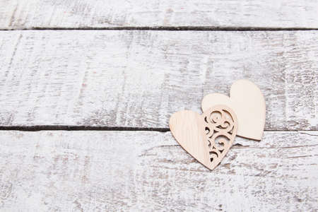 wooden hearts on gray boards, copy space, aged wooden plank background painted white, wood texture, natural material, love on Valentine's Day concept, laser cut out heart patternsの写真素材