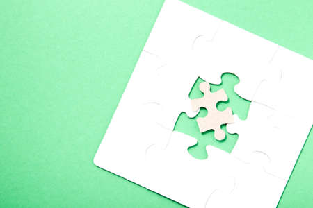 white puzzles on a pink background, folded puzzle, one piece is missing, instead a piece from...