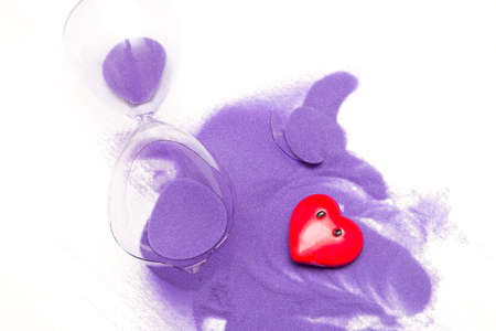 broken hourglass with shiny purple sand and a red heart with eyes without emotion, broken heart...