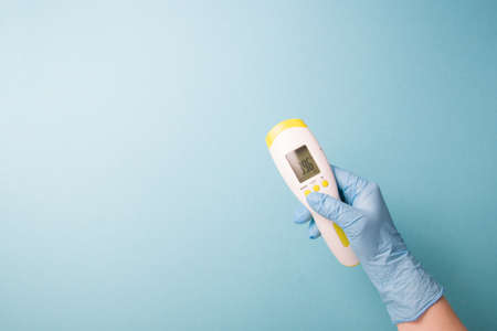 infrared non-contact temperature thermometer in hand, hand in glove, instantly measure temperature,...