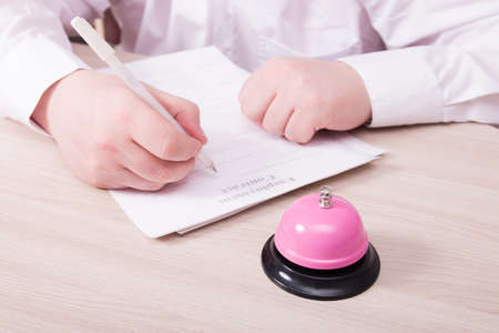a man in a white shirt sits at a table and signs an employment contract, on the table is a service...