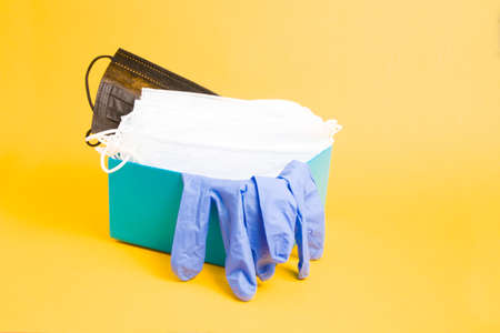 inscription plate and medical face masks and rubber disposable gloves in a blue box, purple background, copy space, coronavirus concept, donation boxの写真素材
