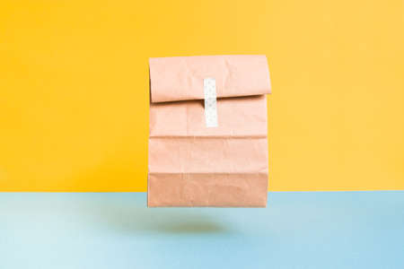 flying paper bag with sticker, food delivery concept, contactless online food delivery home, copy...