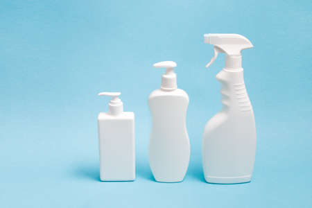 several white plastic bottles with different types of dispensers on a blue background, two white...
