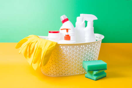 yellow rubber gloves, a yellow rag for cleaning and different white plastic bottles with detergents...