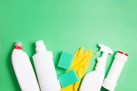 yellow rubber gloves, green sponges for washing and several different types of white plastic bottles...
