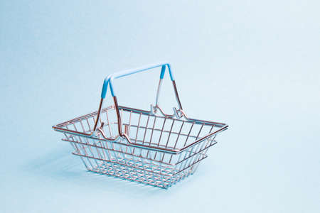 small toy basket on a light blue background, copy space, shopping concept