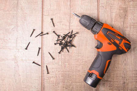 black wood screws black screwdriver on a brown wooden backgroundの写真素材