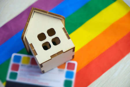 credit card and a small wooden house on the flag of the lgbt community, purchase of suburban real estate by same-sex couplesの写真素材