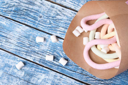 marshmallows wrapped in paper on blue wooden background
