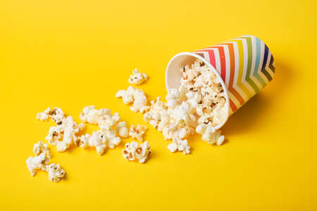 popcorn in bright holiday paper cup on yellow backgroundの写真素材