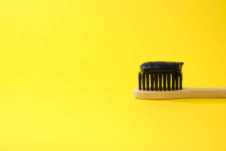 Toothbrush with black charcoal toothpaste. Black toothpaste on toothbrush with activated charcoal pills.の写真素材